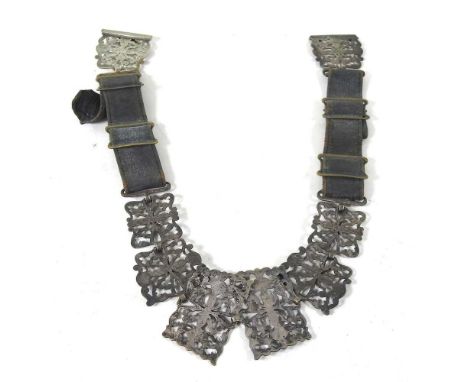 An early 20th century silver plated and leather belt, with pierced decoration and a hinged clasp, 61cm wide