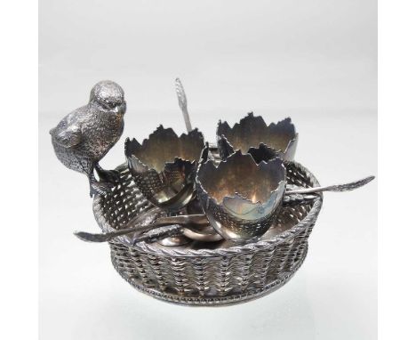 A Victorian silver plated novelty egg cruet, in the form of a chick, perched on a basket, containing three egg cups and spoon
