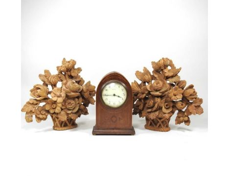 An Edwardian mantel clock, of lancet shape, 22cm high, together with a pair of wooden carvings (3)