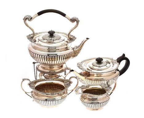 FOUR PIECE EMBOSSED SILVER TEA SERVICE WITH SCROLLED HANDLES AND A CIRCULAR FOOT BASE. COMPRISING:SPIRIT KETTLE ON STAND.LOND