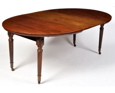An early 19th Century style mahogany extending dining table, the D-ends with three central leaves above plain frieze, applied