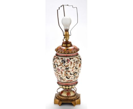 Persian influenced giltmetal mounted earthenware oil lamp, converted to electricity with detachable reservoir above ovoid bod