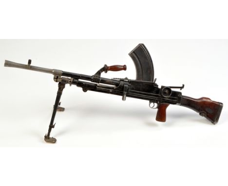 A WW2 Enfield Bren .303 cal. light machine gun, with aluminium fore barrel, hinged bipod stand, turned wooden handle, the bar