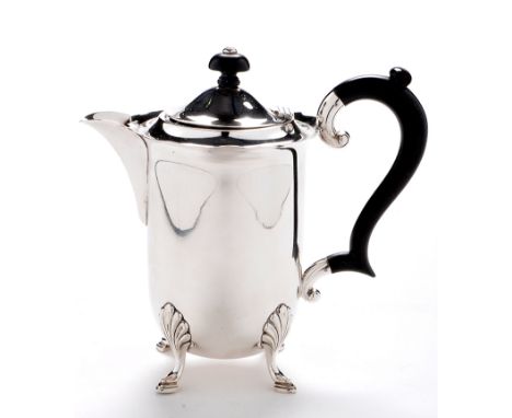 A George VI hot water jug, by Suckling Ltd., Birmingham 1939, circular with cut rim, ebonised finial and scroll handle, 7 1/2