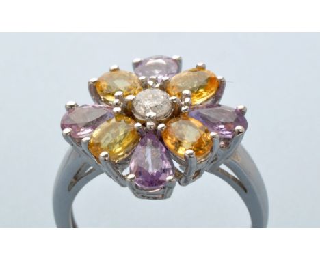 A pink and yellow sapphire and diamond ring, the central brilliant cut diamond surround by four oval yellow sapphires and fou