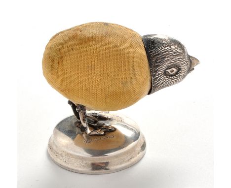An Edwardian silver pin cushion, in the form of a standing chick, maker's mark warn, possibly that of Cohen & Charles, Birmin