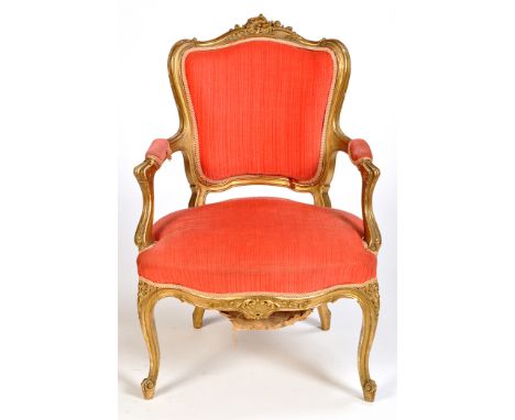 A French Louis XV style carved giltwood open arm fauteuil, the serpentine cresting rail carved with floral scrolls, upholster