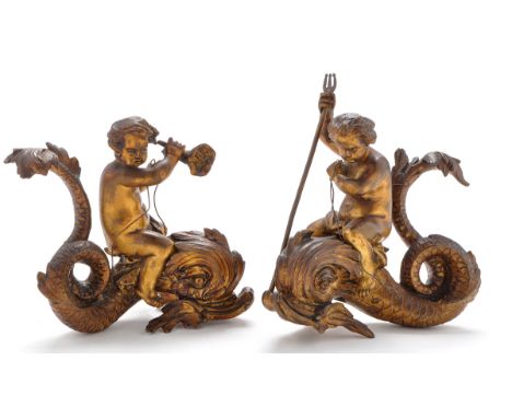 A pair of Ormolu figurines of cherubs riding dolphins, one holding a trident, the other a cornucopia, each 5 1/2in. (14cms) w
