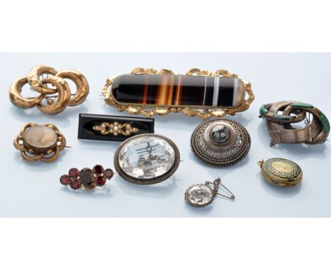 A quantity of mainly 19th Century brooches, including: a banded agate brooch in scrolling giltmetal mount; two rock crystal b