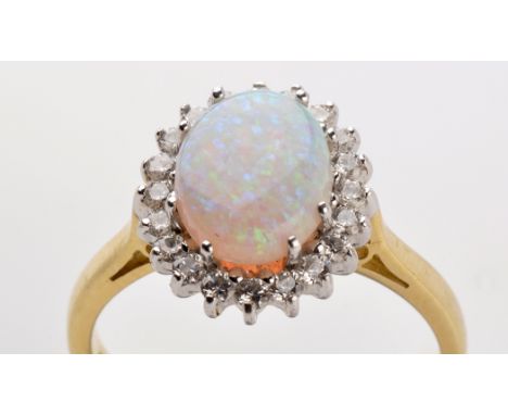 An opal and diamond cluster ring, the oval opal cabochon measuring 10 x 8mm, surrounded by many brilliant cut diamonds, white