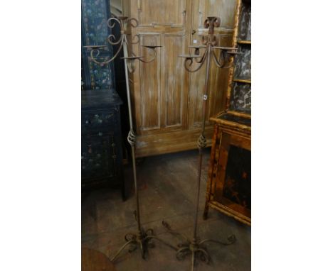 A pair of elaborate metallic standing candelabra with four sweeping branches and on scrolling tripod supports 