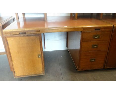 A vintage kneehole office desk with cupboard flank and flank of three drawers