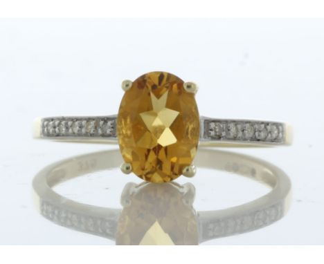 An oval 8mm x 6mm Citrine sit between ten round brilliant cut diamonds on the shoulders on this 9ct yellow gold diamond ring.