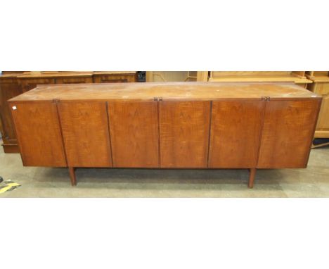A 1960's teak sideboard, possibly Robert Heritage, the rectangular top above six doors, with internal fitted shelves and draw