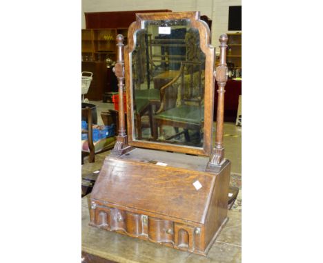 An oak dressing table mirror in the form of a fall-front bureau, with fitted interior and shaped bevelled plate above, 74cm h