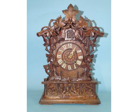 A late-19th/early-20th century Black Forest 'chalet' case mantel cuckoo clock, with carved and applied leaf decoration, the m