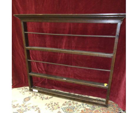 An antique oak hanging plate rack with simple moulded cornice above three shelves, 132cm wide, 117cm high. 