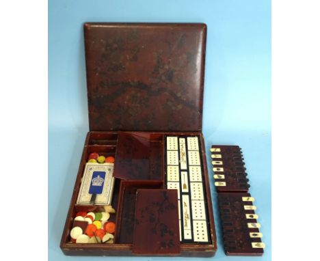 A Japanese lacquer games compendium, the square box and cover with flowering branch decoration on a red ground, containing tw
