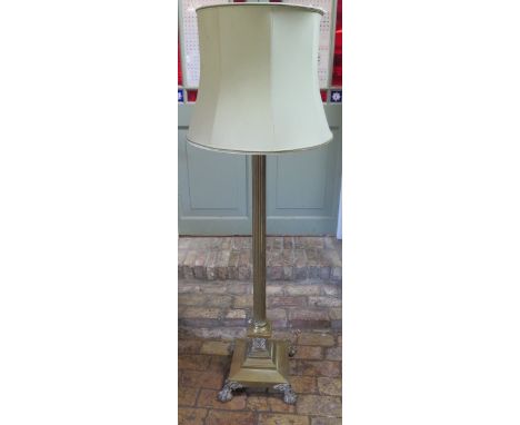 A brass Corinthean column standard lamp on ball and claw feet, 162cm tall, will need re-wiring 