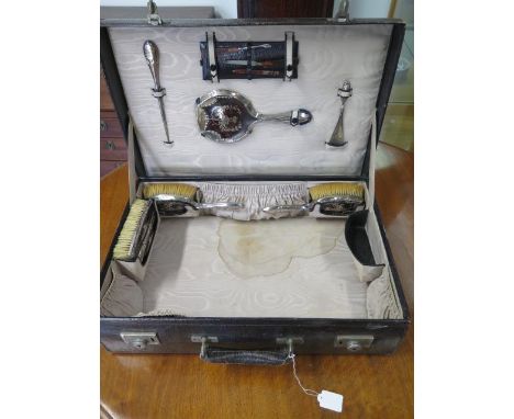 A black leather fitted suitcase with a silver tortoiseshell five piece dressing set with silver handle button hook and shoe h