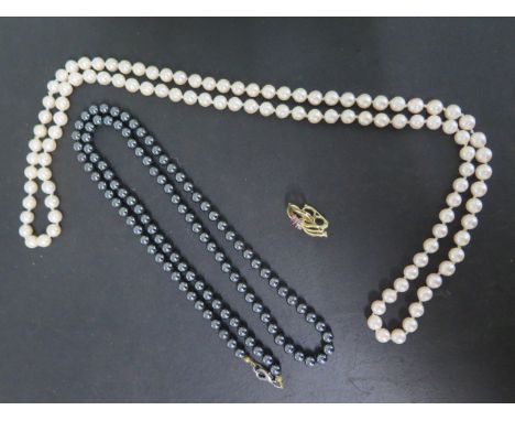A string of pearls, 88cm long, with a 14ct yellow gold diamond and ruby separate clasp and a 75cm string of Hemazite beads, a