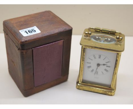 A brass carriage clock 11 cm tall with travel case, in working order, glass good 