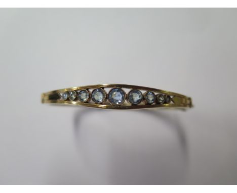 A 15ct gold hinged bangle with 9 round aquamarines from 2mm to 4mm, French circa 1920, weight approx 10.5 grams, 6.5cm x 5.5c