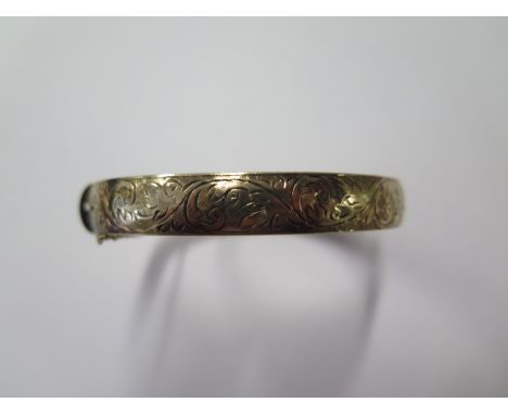 A 9ct gold 8.7mm wide half engraved hinged bangle, approx weight 28.8 grams, 6.5cm x 5.5cm, in good condition 