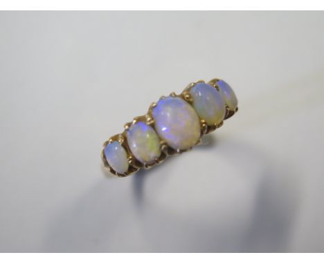 A gold graduated opal five stone ring with 1 7x 5mm, 2 5x3mm and 2 x 3 x 2.5mm oval watery blue crystalline milk opals, size 