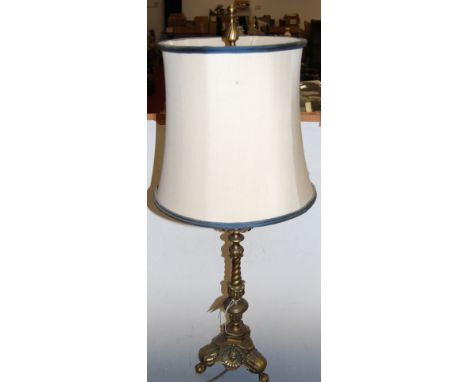 A large brass table lamp, having spirally turned column to a triform base, with claw and ball feet, h.98cm