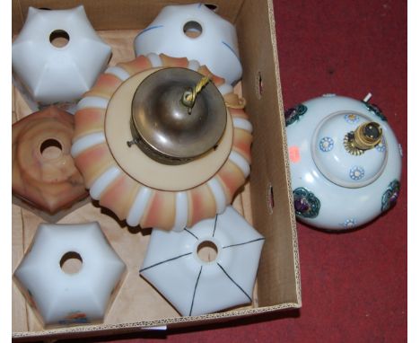 A collection of early 20th century painted glass light shades; together with a pottery table lamp base