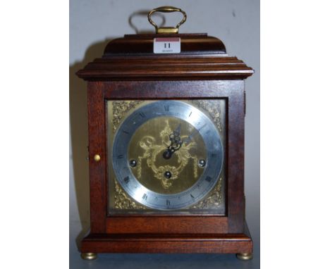 A modern mahogany cased mantel clock, the silvered dial with Roman numerals, within pierced brass spandrels, having eight day