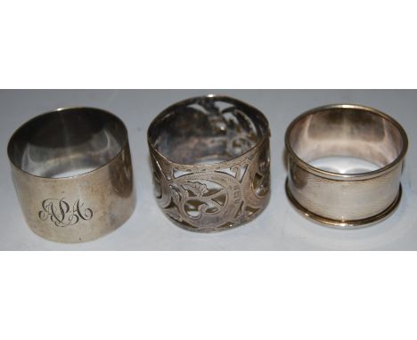 An Edwardian silver napkin ring of pierced circular form, together with two other silver napkin rings (3)