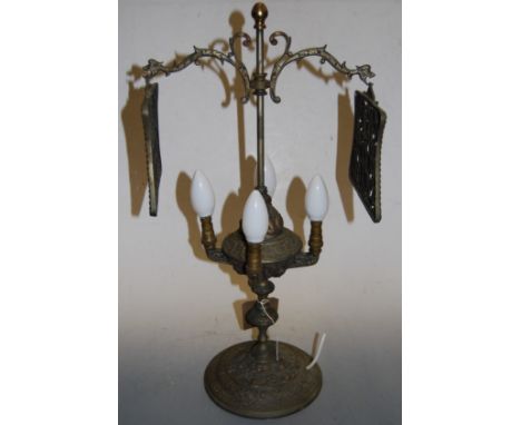 A Continental brass four sconce table lamp, having adjustable fitting with pierced brass hanging panels, the base embossed wi