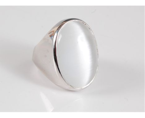 A silver and moonstone ring, the oval chatoyant moonstone cabochon, approx. 26 x 18mm, in a deep collet mount tapering in to 