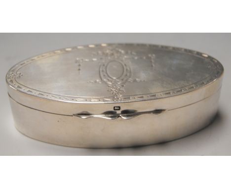 An early 20th century silver trinket jar and cover of oval form, the hinged oval lid engraved with swags and bows, maker Jame
