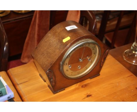 An oak cased three hole mantel clock