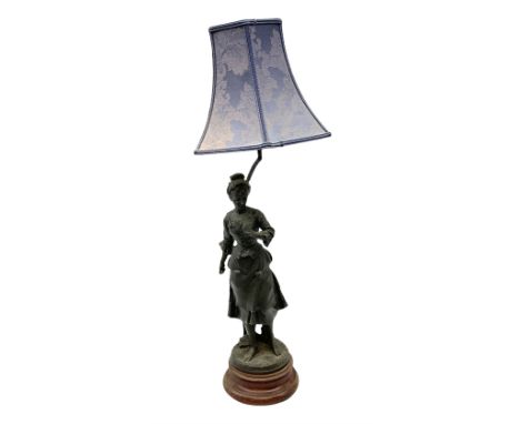 French figural spelter lamp modelled as a lady upon turned stepped circular base with blue fabric shade, H76cm