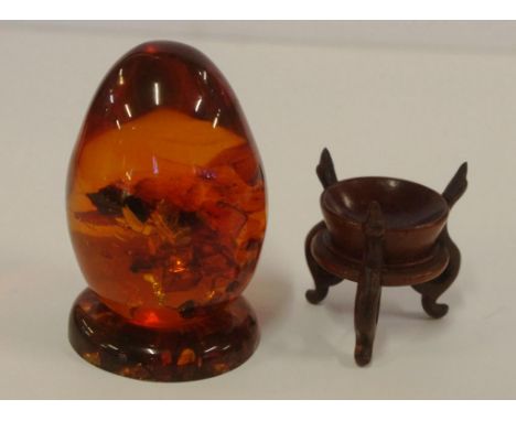 Amber egg on stand together with a carved wooden stand