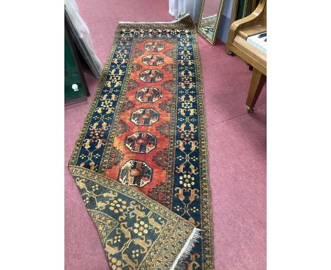 Middle Eastern Wool Runner, with eight octagonal motifs, to rust grounded centre within blue decorative border, 282 x 89cm.So