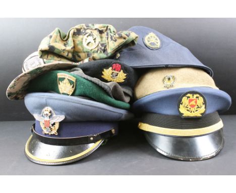 A collection of ten military caps and berets with associated badges to include Serbia Air Force, Vietnam Army, Canadian Royal