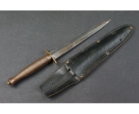 A Fairbairn Sykes commando fighting knife, spearpoint double edge blade measures 17.5cm, brass oval cross guard stamped with 