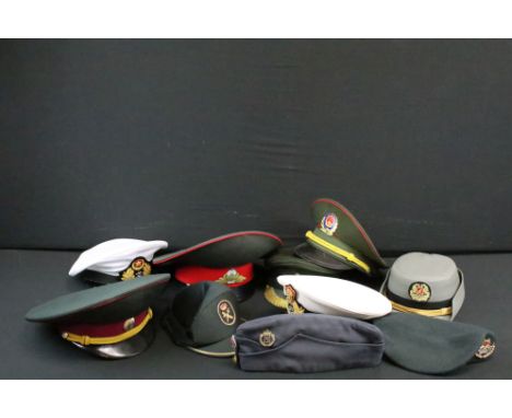 A collection of ten military caps and berets together with associated badges to include Ukraine Army, Pakistan Navy, Indian N