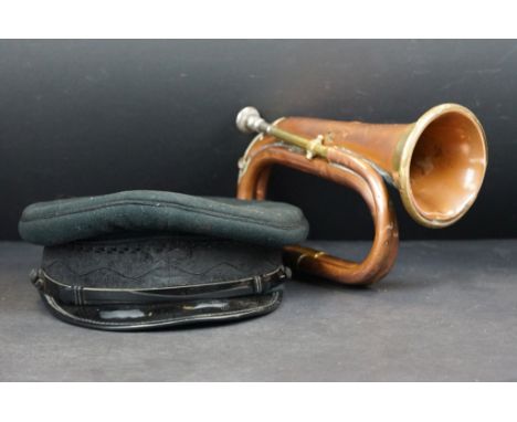 A vintage military copper &amp; brass bugle together with a military peaked cap. 