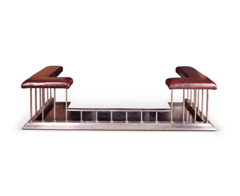 A POLISHED STEEL CLUB FENDER  EARLY 20TH CENTURY  Maroon leather upholstered on square supports  external at base 178cm wide,