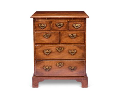 A WALNUT CHEST  19TH CENTURY The rounded rectangular top with above a slide and an arrangement of five short and two long dra