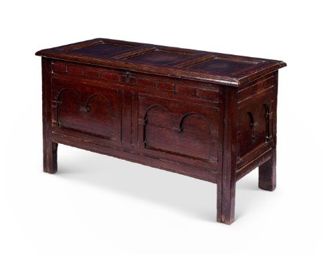 AN OAK COFFER 17TH CENTURY     With triple-panelled hinged lid and double arcaded fielded front with conforming sides on chan