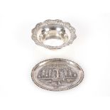 A Continental white metal shallow oval pin dish, decorated with dancing figures around a serpent and