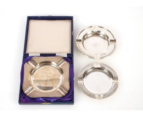 A cased silver ash tray, with engine turned decoration, Birmingham 1983; a small circular similar, Birmingham 1935; and anoth