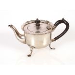 A late Victorian silver bachelors tea pot, having serrated border and black wood handle and lift,